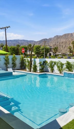 Pool with lime-green lounge chairs, spa, and Santa Rosa Mountains at La Quinta Splash Inn